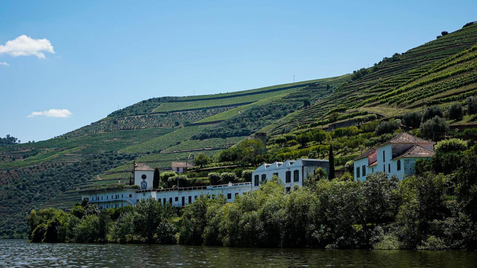 A picturesque scene of a Douro River cruise ship navigating through the narrow, historic locks in Portugal's UNESCO World Heritage valley