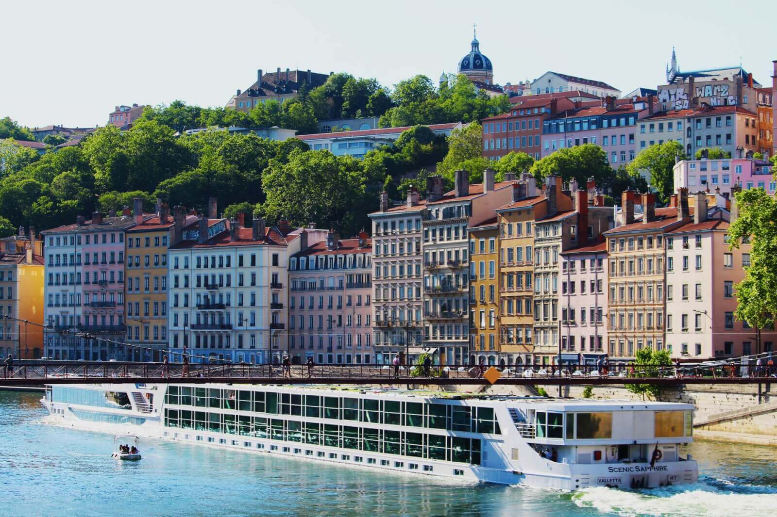 A luxurious river cruise ship docked along the picturesque Rhone River in Lyon, France.