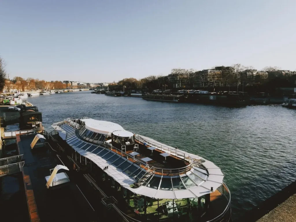 <alt for query 0>: A picturesque view from the deck of a Seine river cruise ship in Paris during sunrise.